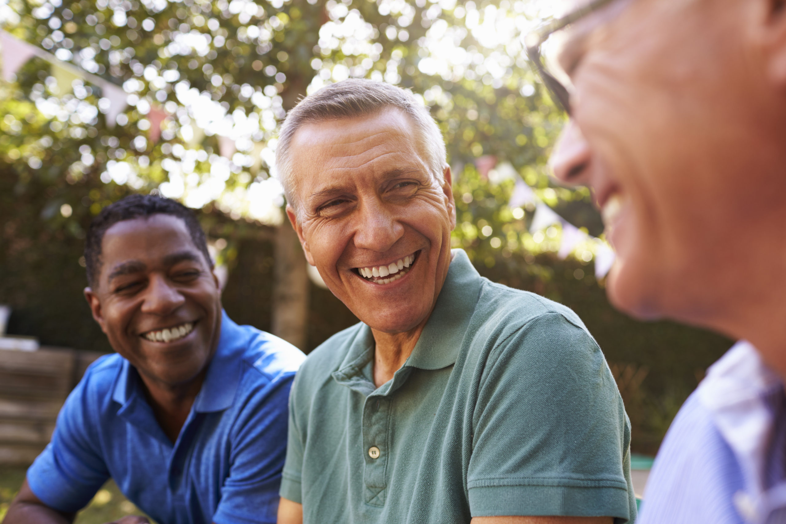 Mature Male Friends Socializing In Backyard Together